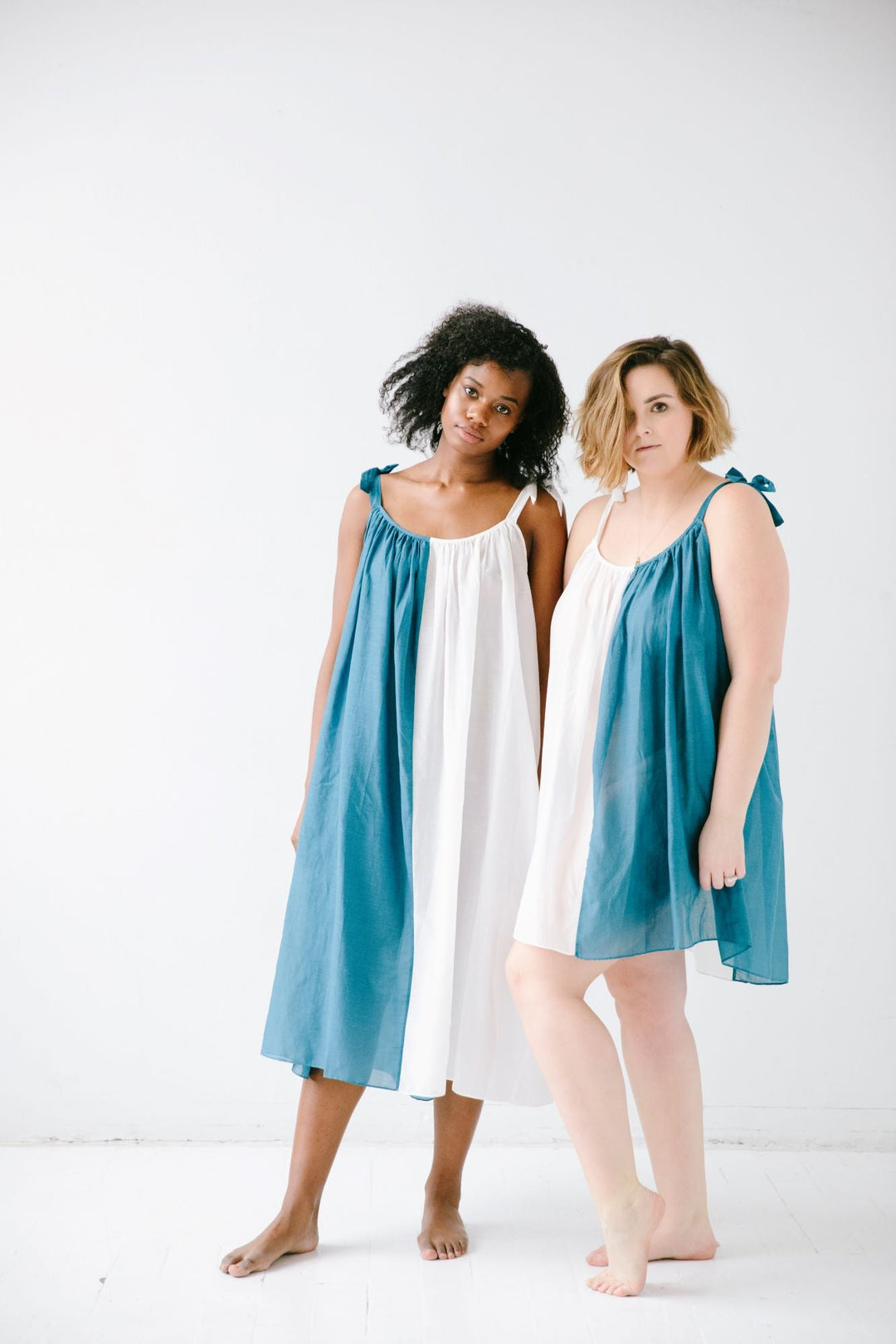 Two sheer tie-strap babydolls in teal and white, gathered bodice
