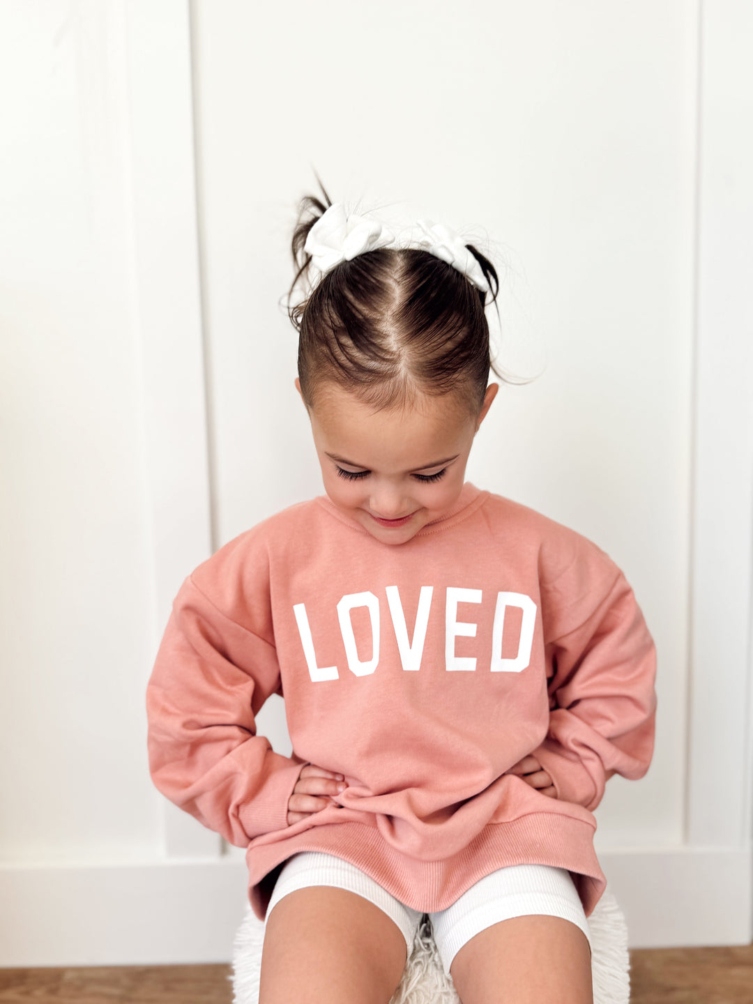Salmon pink crewneck sweatshirt showing &