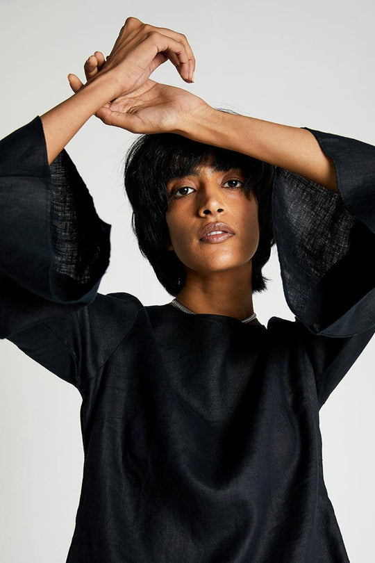 The Button Back Shirt in black with loose fit and wide bell sleeves.