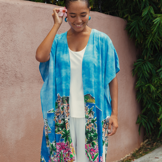 Blue kimono jacket with graphic town-and-flower print, open front over white top, short sleeves