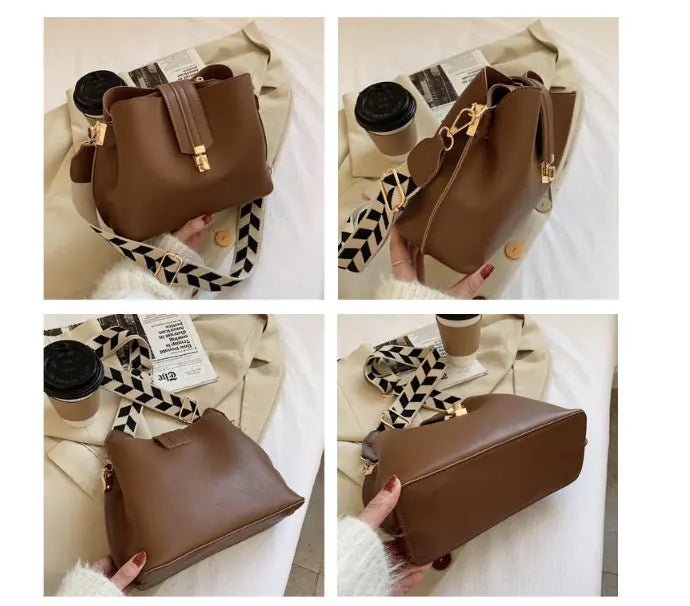 Brown bucket bag with top handle, gold-tone clasp, and patterned crossbody strap