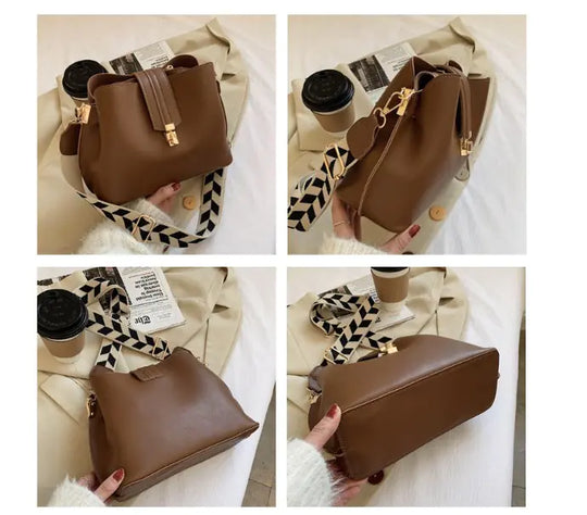 Brown bucket bag with top handle, gold-tone clasp, and patterned crossbody strap