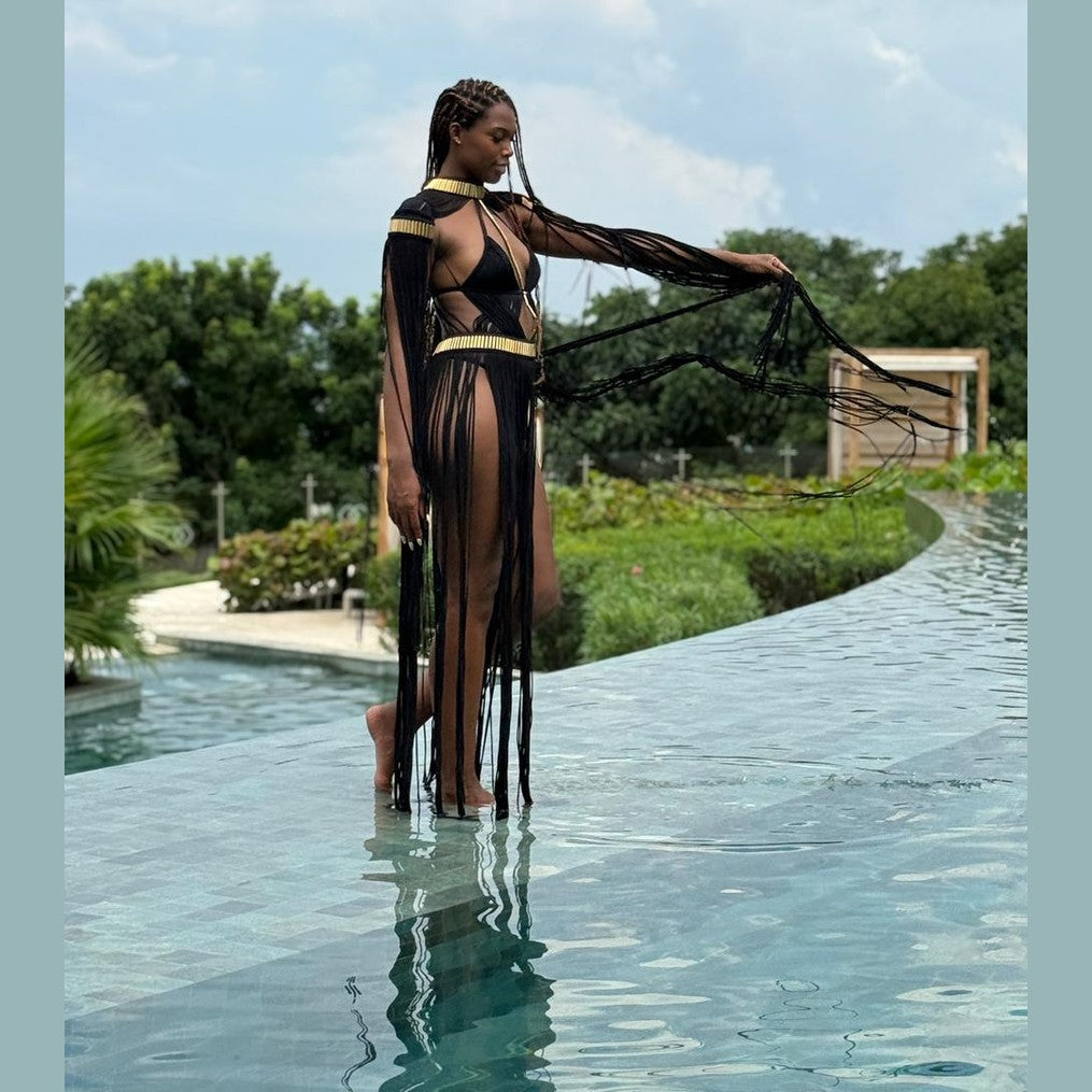 Grecian Elegance Calypso dress back view in black with gold trim and flowing fringe