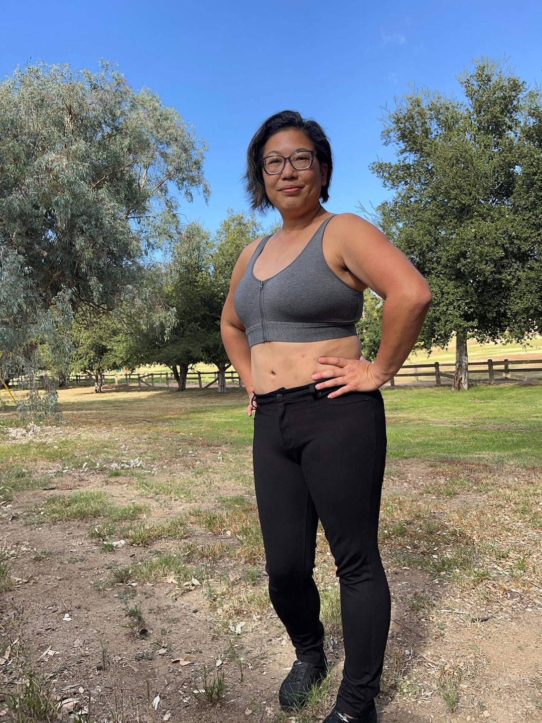 Grey cotton bralette with front zipper closure, worn with high-waist pants