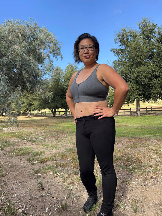 Grey cotton bralette with front zipper closure, worn with high-waist pants