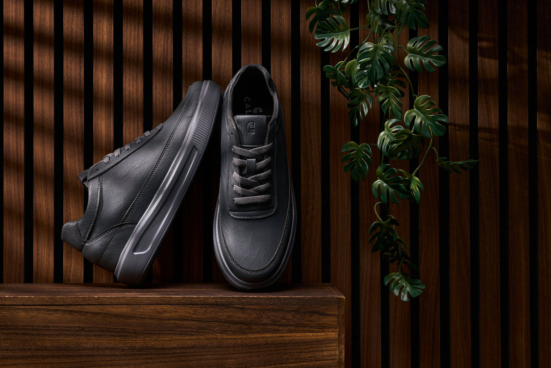 Iron grey lace-up sneakers with thick sole, stitched overlays, and side logo