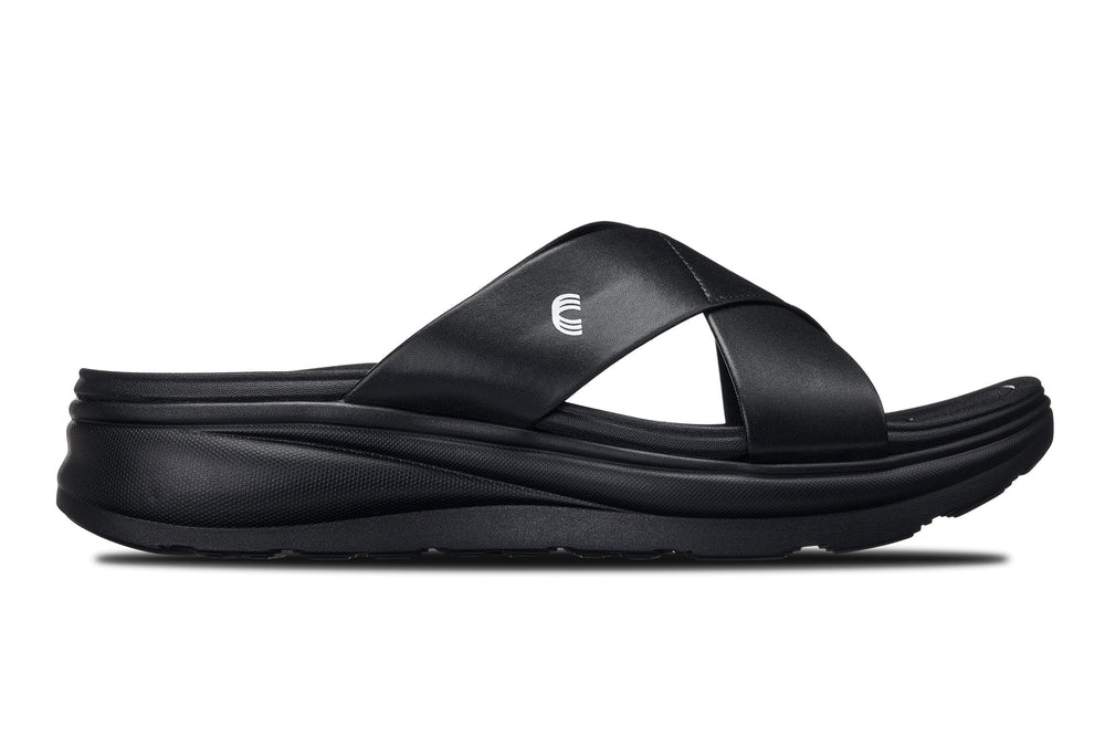 Black matte slide sandals, side view, cross strap on a cushioned platform sole.