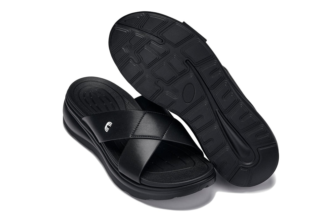 Black matte slide sandals with textured outsole patterns and cushioned footbed visible.