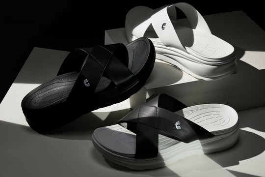 Black matte slide sandals from above, cross straps and embossed logo on the footbed.