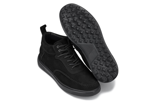 Black suede sneaker boots with outsole tread pattern visible under the shoe