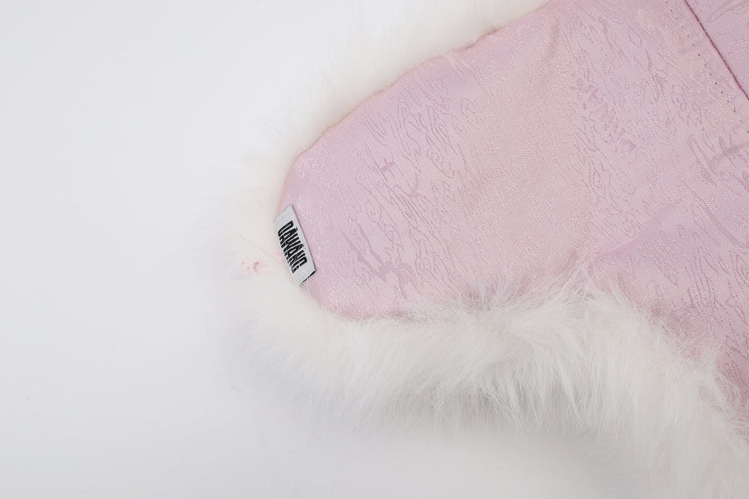 Pink patterned satin lining panel with black-and-white brand tag and faux-fur edge
