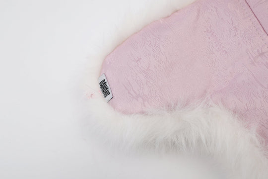 Pink patterned satin lining panel with black-and-white brand tag and faux-fur edge