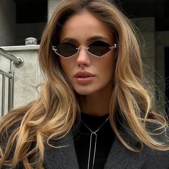 Cat-Eye Sonnenbrille, goldfarbener Metallrahmen, dunkle Gläser, frontal getragen