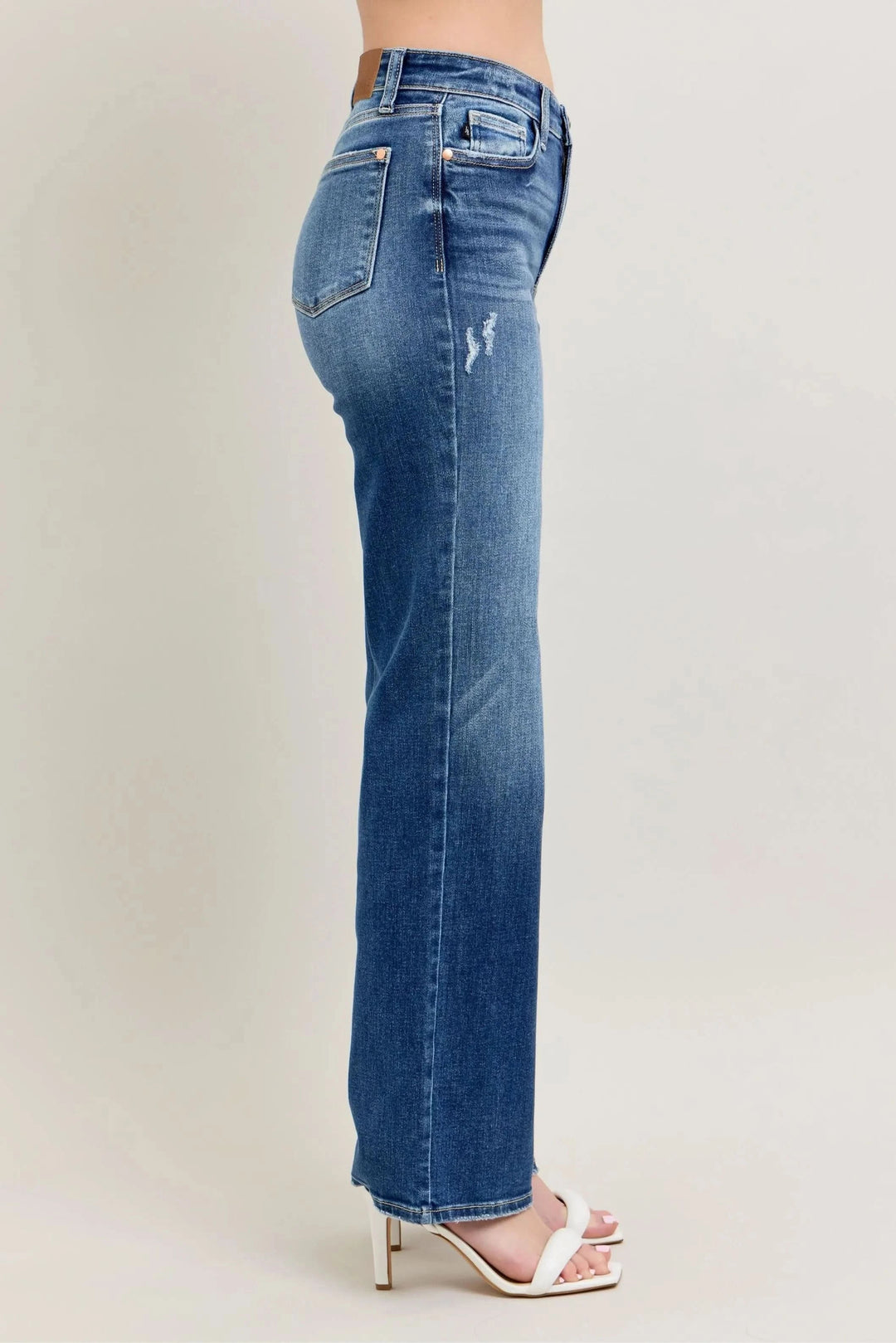 Side profile of high-waist straight-leg jeans with worn whisker marks, medium blue wash