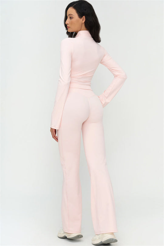 Side view of light pink flared leggings with smooth fit through hips and wide flare hem