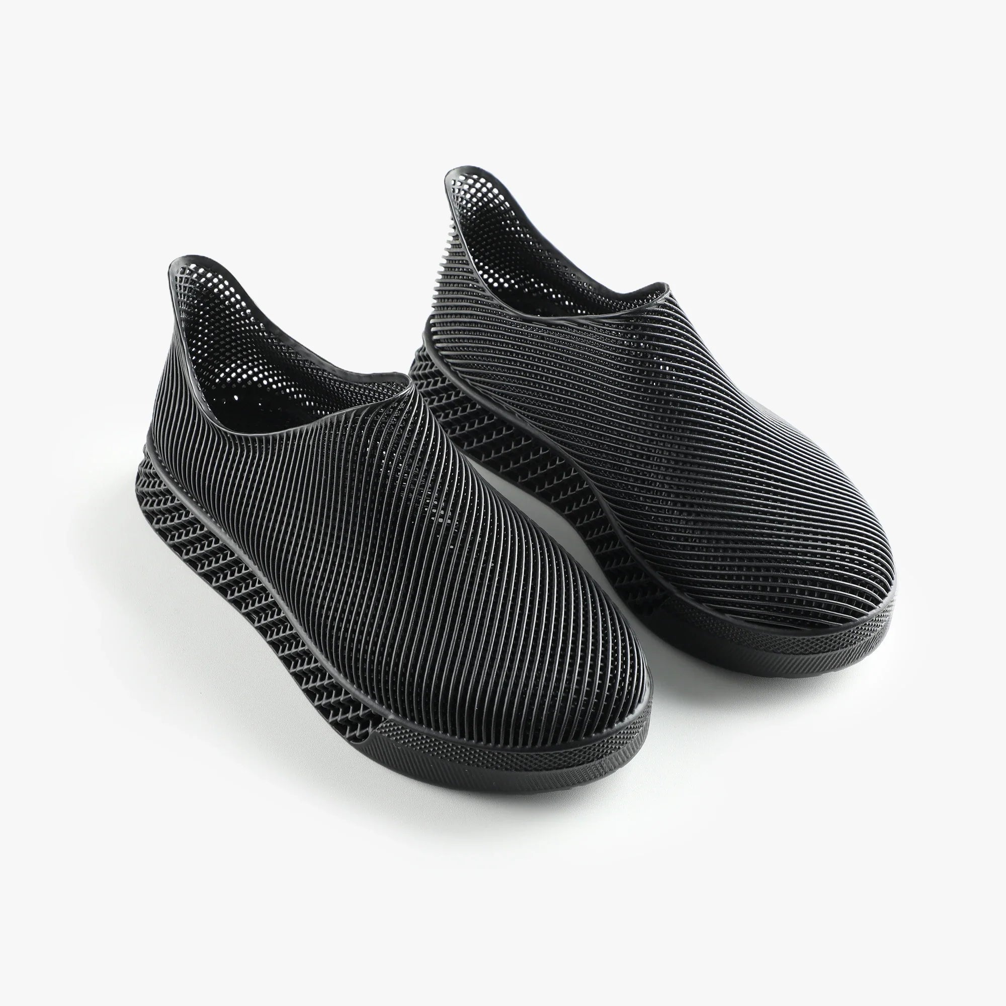 Black 3D printed slip-on sneakers with ribbed knit upper and textured sole