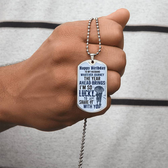 Happy Birthday dog tag necklace on a silver chain held in hand