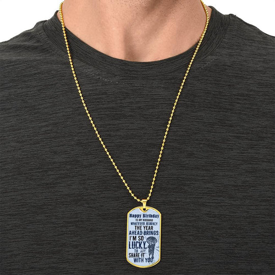 Happy Birthday dog tag necklace on a gold chain worn on a man’s chest
