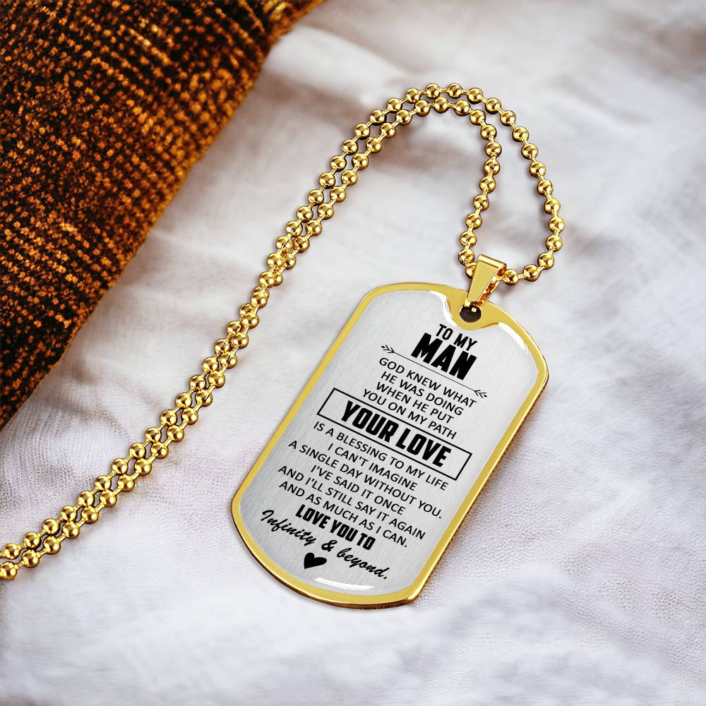 Gold dog tag necklace on white fabric, engraved &