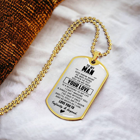 Gold dog tag necklace on white fabric, engraved &