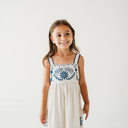 Sleeveless linen dress with blue floral embroidery at chest and vertical panel stitching