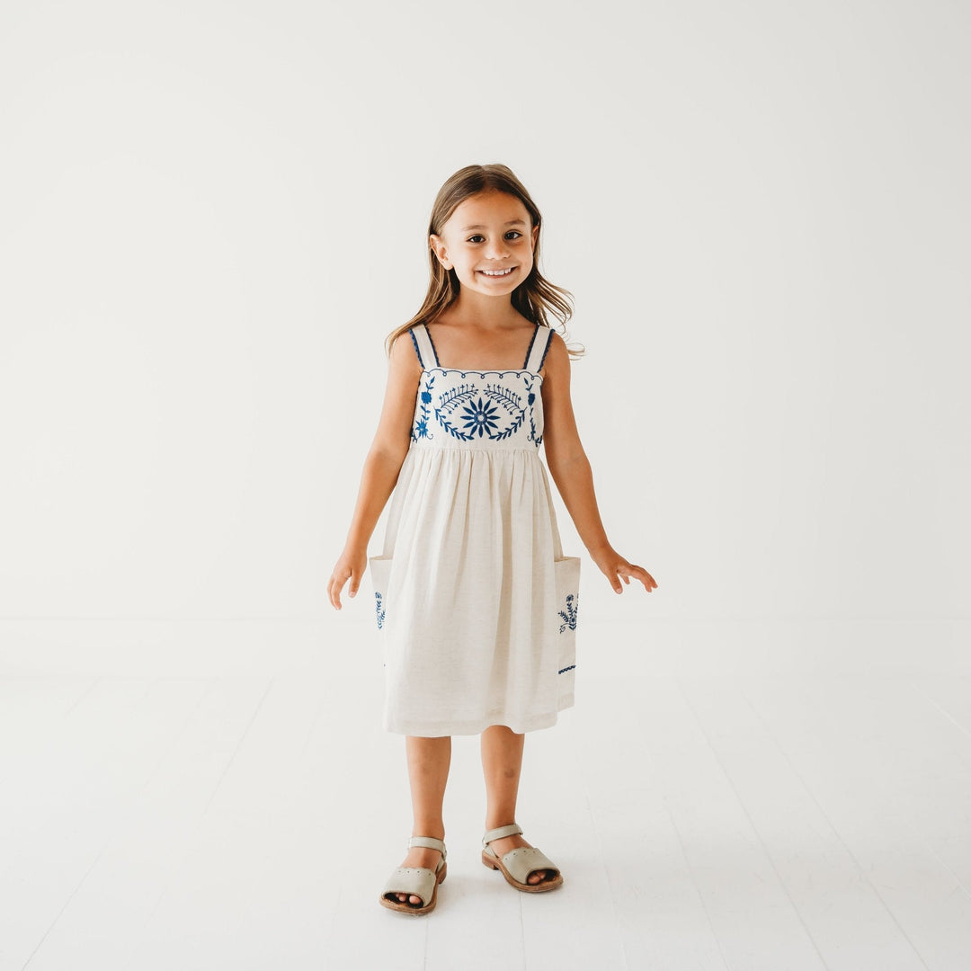 LARILI azurea linen dress on child model, blue embroidered yoke and gathered skirt