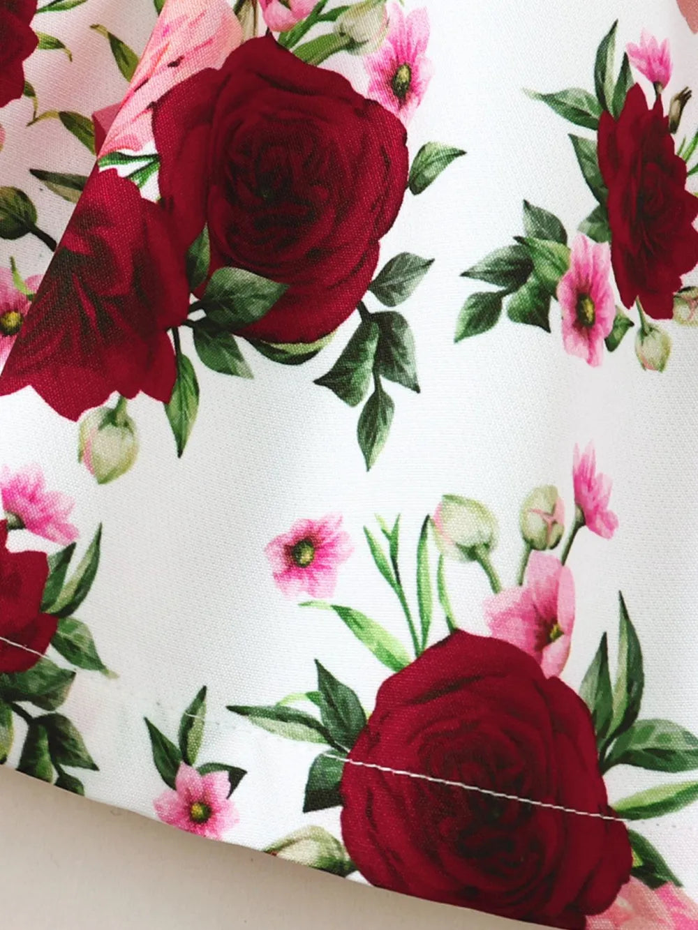 White floral fabric with deep red roses and pink blossoms