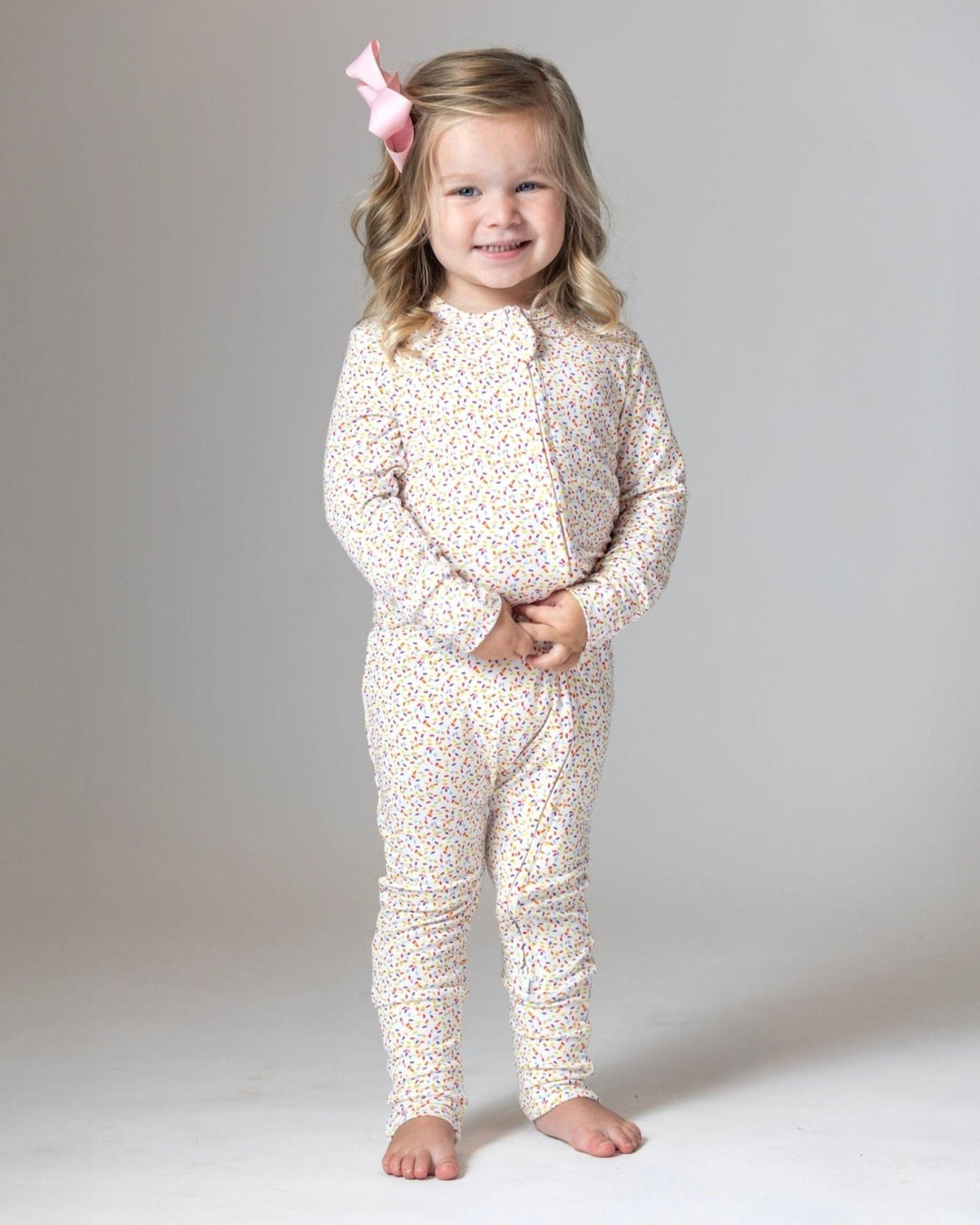 Bamboo romper pajamas, white with multicolor confetti dots, front view on child