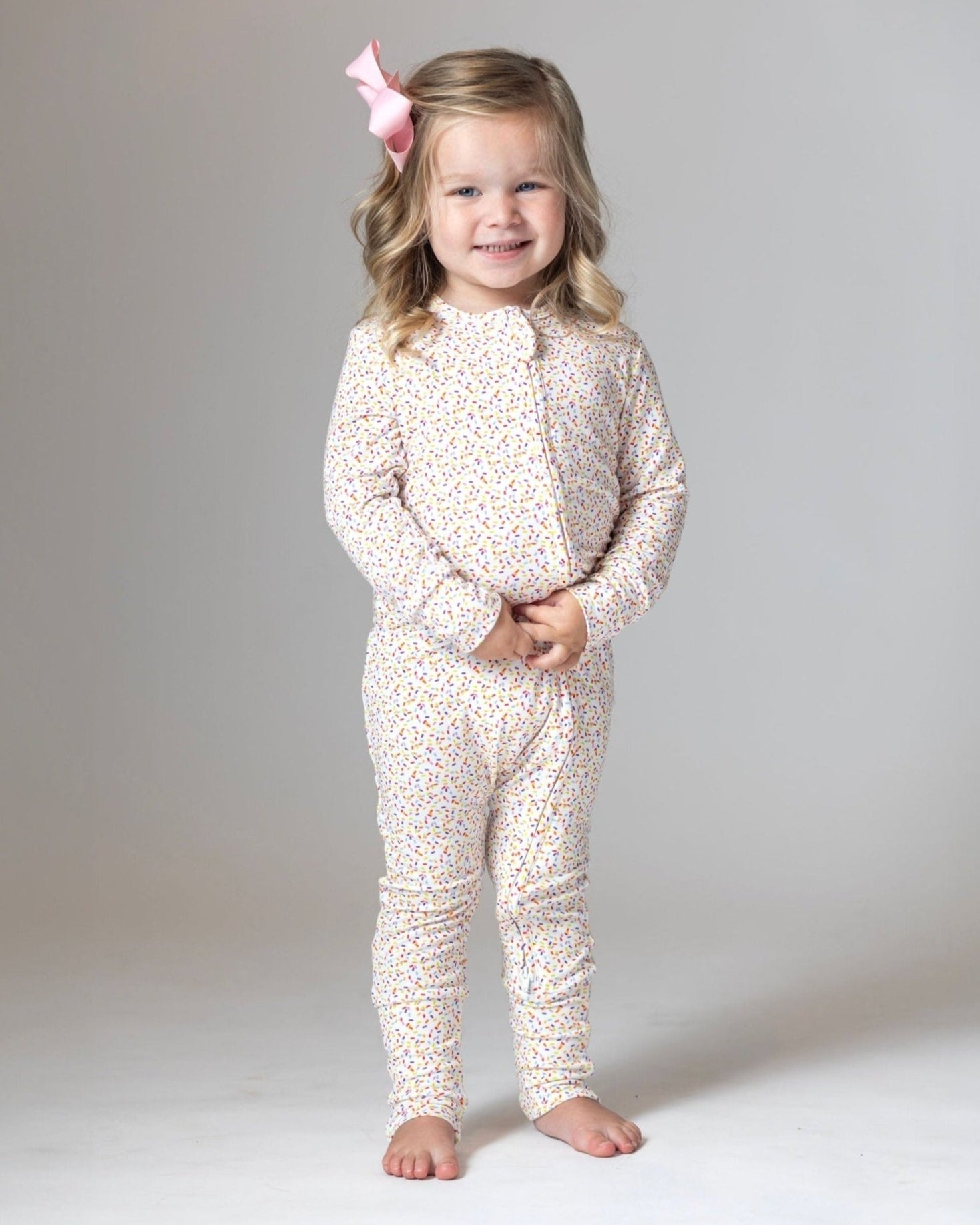 Bamboo romper pajamas, white with multicolor confetti dots, front view on child