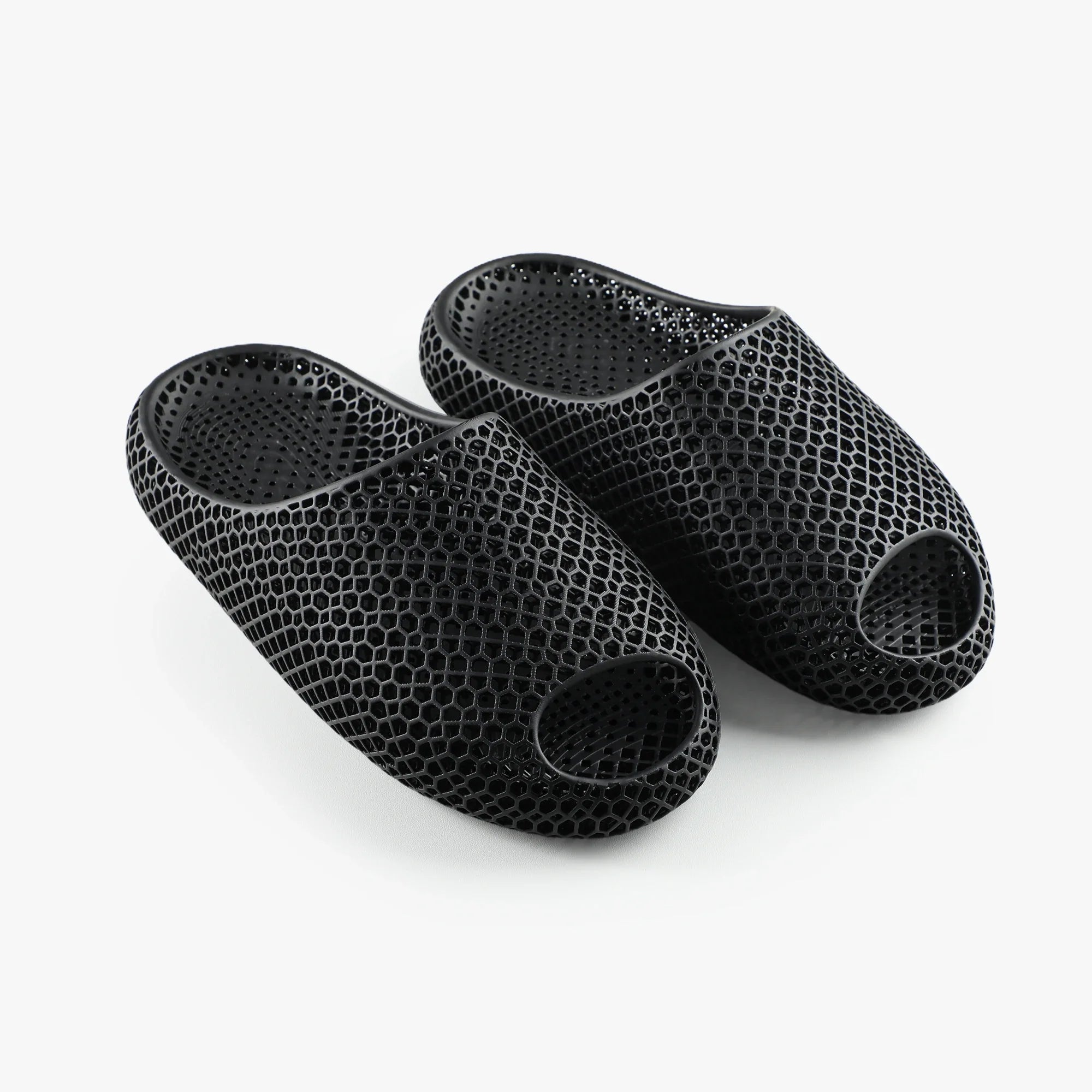 3D printed slip-on slippers in dark textured mesh with open toe and rounded sole.