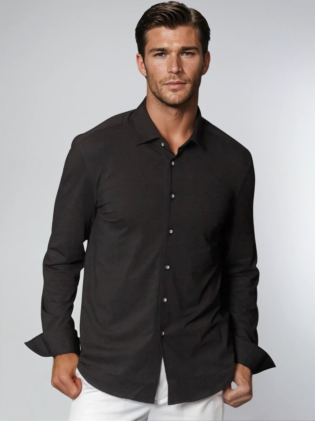 Black button-up shirt on model, long sleeves, collared neckline, button-front placket