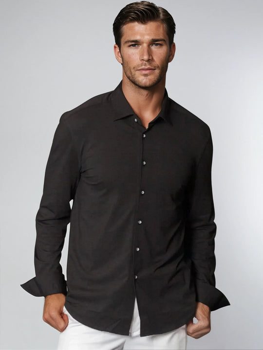Black button-up shirt on model, long sleeves, collared neckline, button-front placket