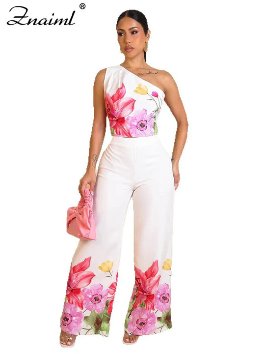 White floral two-piece outfit: one-shoulder crop top with wide-leg pants, pink flower print