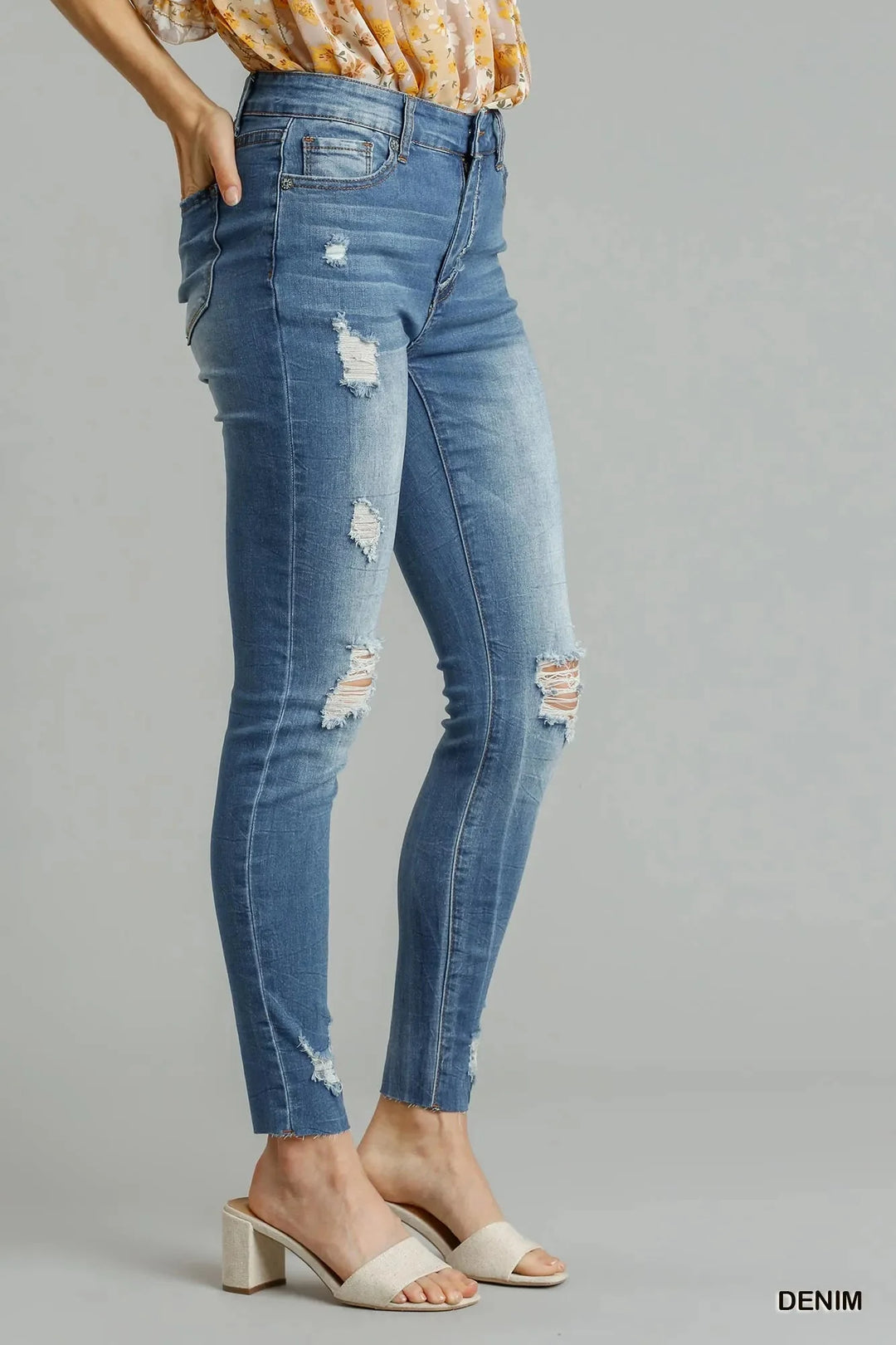 High-waist skinny jeans with ripped knees and distressed leg panels, raw hem
