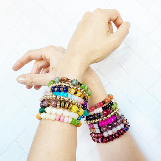 Perlenarmband auf Handgelenk: mehrreihig, bunte Perlen mit goldfarbenen Metallkappen