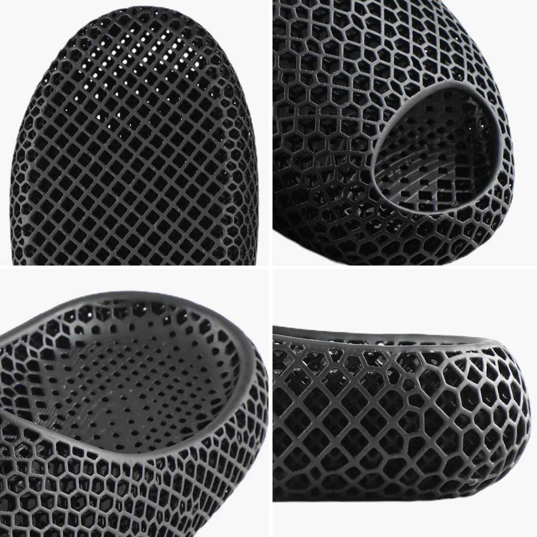 Black 3D-printed slipper close-up, perforated honeycomb texture and round toe opening