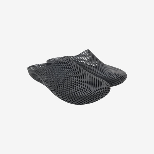 Black 3D printed slippers with openwork grid texture, slip-on clog style.