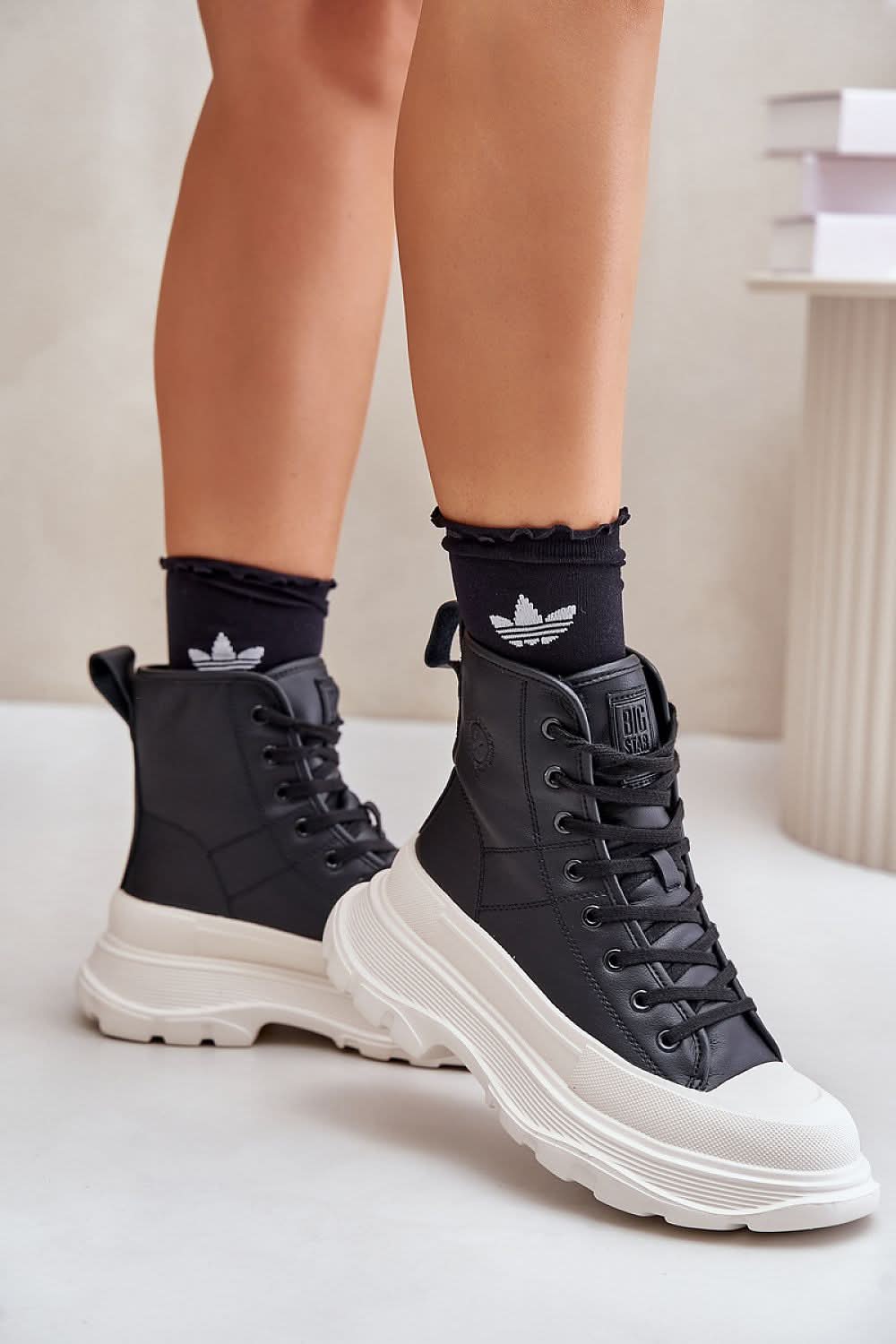 Pair of black high-top leather sneakers, white platform sole, lace-up with emblem