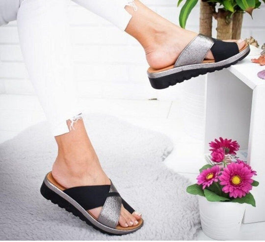 Black women’s slide sandals with silver cross strap and textured rubber sole