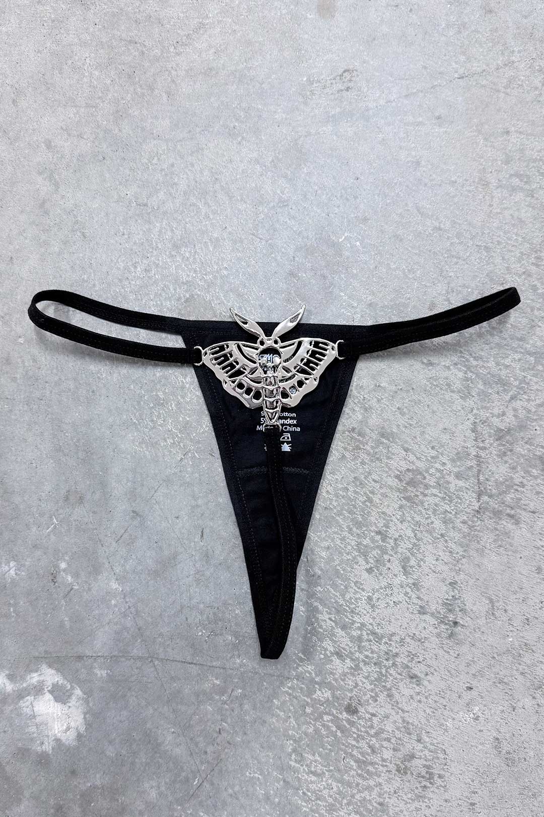 Black metal Death Moth thong with silver winged emblem at center front