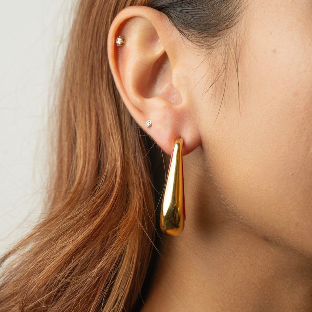 Gold-tone drop hoop earrings with warm golden inner shine