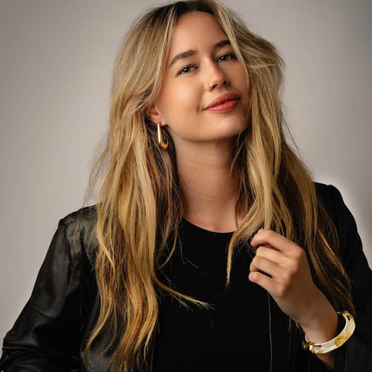 Gold drop hoop earrings on model, extra-large hoops with clear gold leaf inside