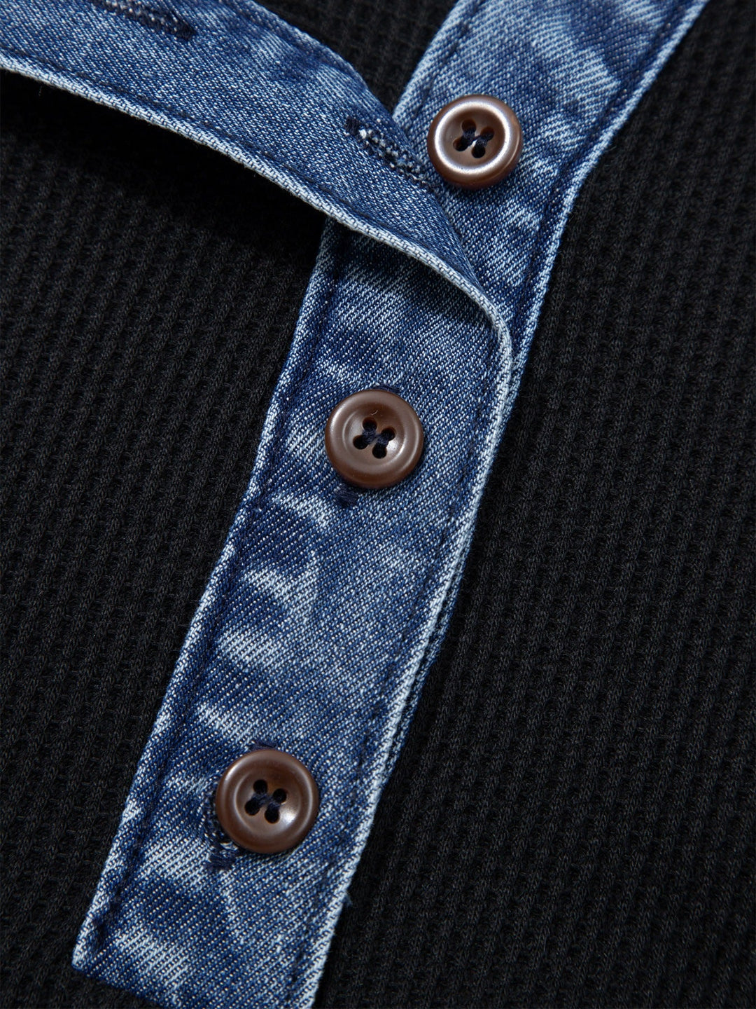 Blue denim placket with three brown buttons on black top