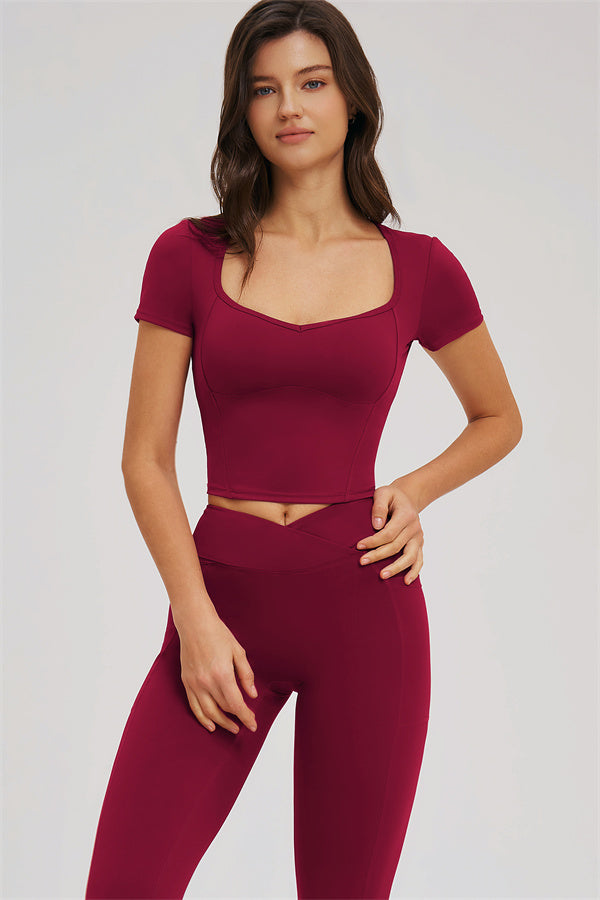 Burgundy crop top with curved seams and high-waist leggings, front close-up