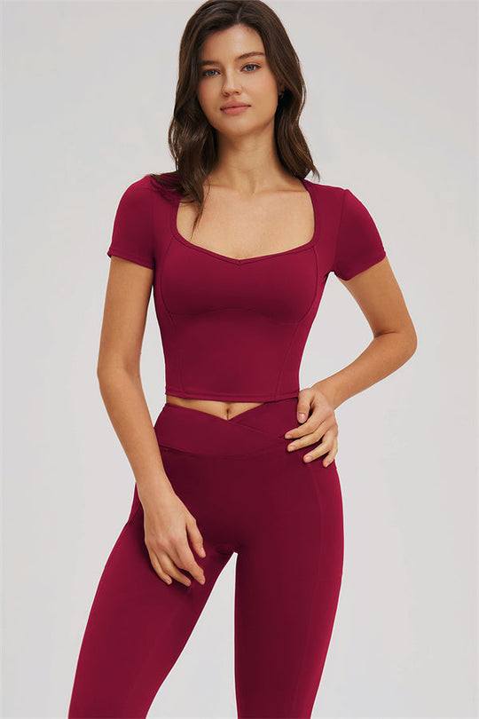 Burgundy crop top with curved seams and high-waist leggings, front close-up