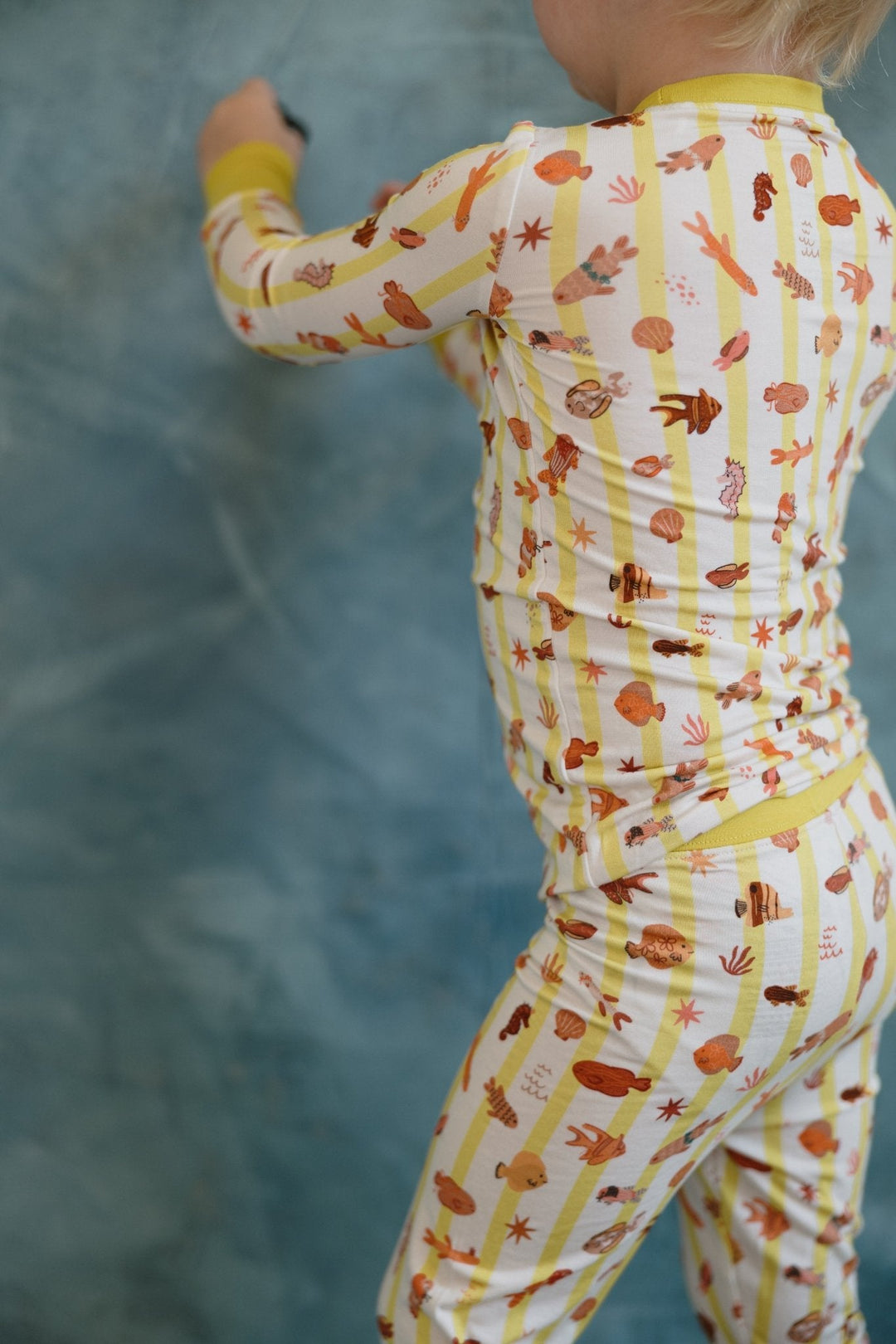Back view of Fancy Fins pajama set: long sleeves and pants with critter print, yellow trim