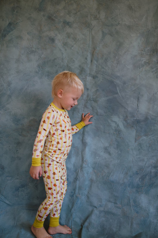 Fancy Fins two-piece pajama set on child: long-sleeve top with matching striped critter pants