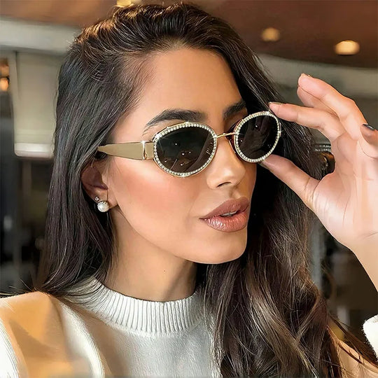 Oval rhinestone sunglasses with dark tinted lenses and gold-tone metal frame