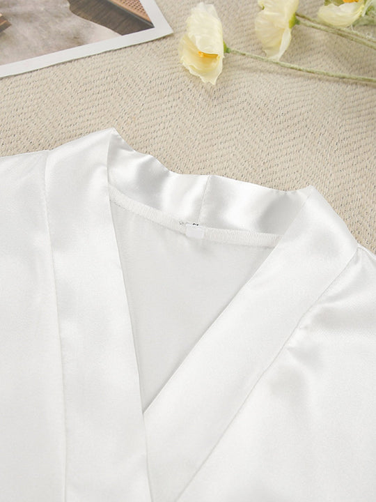 White cardigan fabric close-up with curved neckline seam and draped front panels