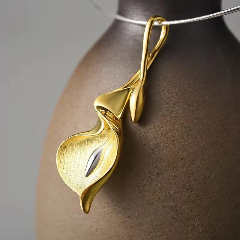 Gold calla lily pendant necklace with open loop design and gold center, on a silver chain